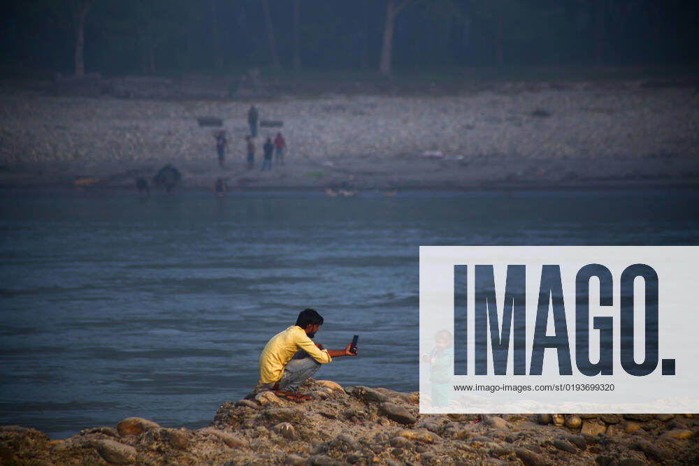 Winter spells in Central Nepal A man clicks photo of a baby as they roam around the edge of Naryani River in Chitwan District of Central Nepal as it is covered with fog on one fine morning. With start of November, mercury levels has dropped across the Himalayan Nation. Chitwan Bagmati Nepal