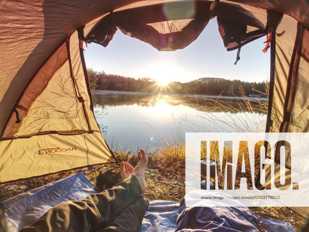 Couple legs rest in tent at lake. Hiker enjoy view outsid and e free hike vacation, model released, , 37033424.jpg, activity, adventure, backpack, beautiful, boots, boyfriend, camping cooker, campsite, cooking breakfast, couple, dinner, feet, foam mat, forest, grass, hike, hiker legs, hiking, holiday, horizon, lake, landscape, man body, mountain, mountains, nail, naked foot, outdoor, pure nature, recreation, rest, scenery, sleeping bag, sleeping mat, socks, sunset, tent, thermos bottle, toes, together, tourism, tourist, travel, tread, trees, trekking, trip, vacation, water, waterproof