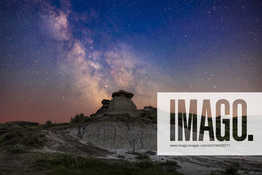 The galactic centre area in Sagittarius (at left) and Scorpius (at right) low in the south on a summer night at Dinosaur Provincial Park, Alberta. This was June 30 July 1, 2022. Being just 10 days after summer solstice and at latitude +50° North, the sky even to the south still has a blue tint from all-night twilight. I made no attempt to neutralize the sky colouration. In addition, some haze from smoke discoloured the sky and reduced transparency and contrast low in the sky. Many of the nebulas and star clusters in this part of the Milky Way are visible, many of them showpiece Messier objects for binoculars and telescopes. The colourful area around the star Rho Ophiuchi above Antares is at right, though muted here by the smoke and haze.