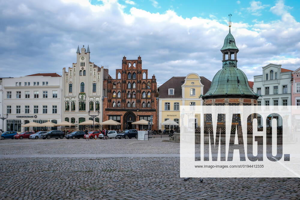 Wismar, Mecklenburg Vorpommern, Germany city view, renovated old town Wismar, renovated houses, renovated facades at the market, in the middle the famous late gothic brick house Alter Schwede, on the right the water art, the well house Wismar Mecklenburg Vorpommern Germany