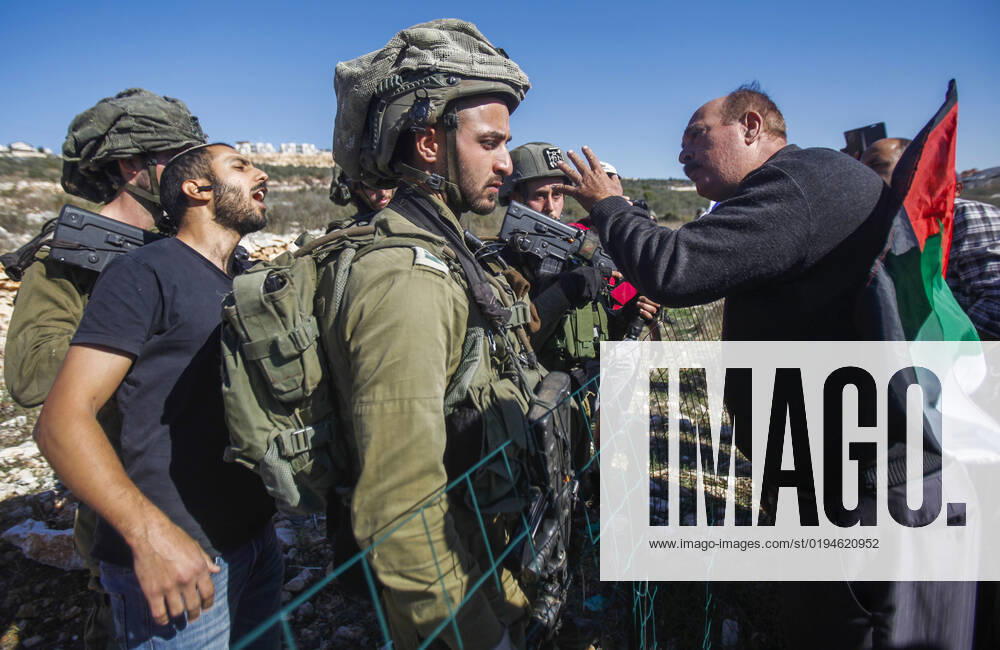Salfit, West bank, Palestine: A Palestinian protester argues with a Jewish settler under protection Israeli soldiers while other settlers seize land from Palestinian farmers in the village of Burqin, west of Salfit, in the occupied West Bank. Palestinians demonstrated against the confiscation of their land by these settlers in favor of the Jewish settlement of Brochin. Salfit Palestine - ZUMAs197 20221120_zaa_s197_082