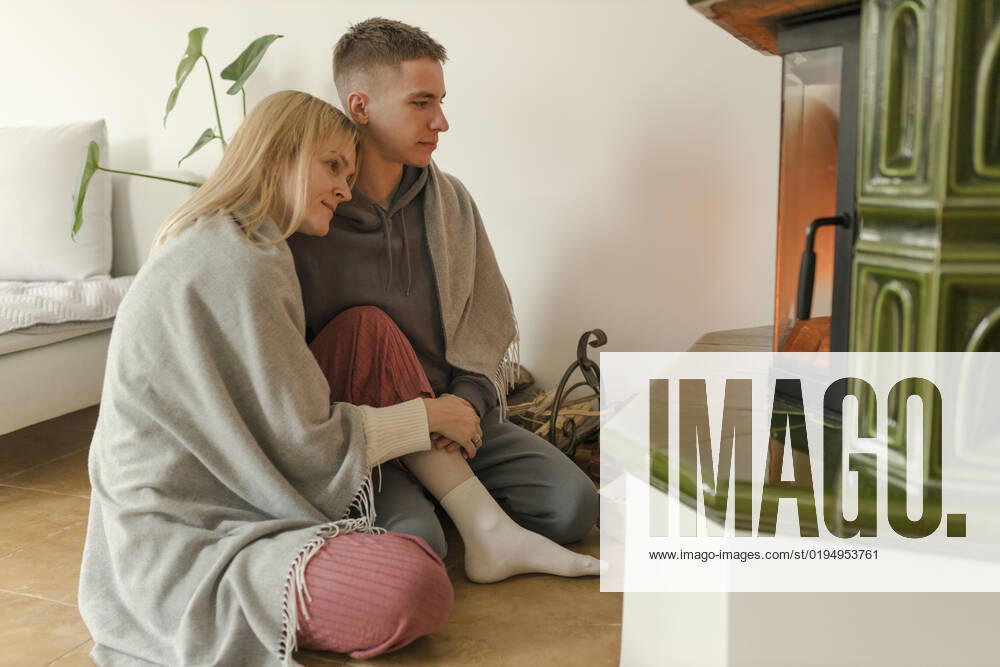 Young couple sitting together in front of fireplace at home model released, Symbolfoto property released, VIVF00127