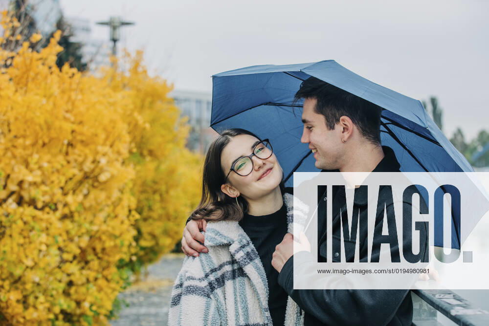 Smiling young man and woman under umbrella in autumn model released, Symbolfoto, VSNF00106