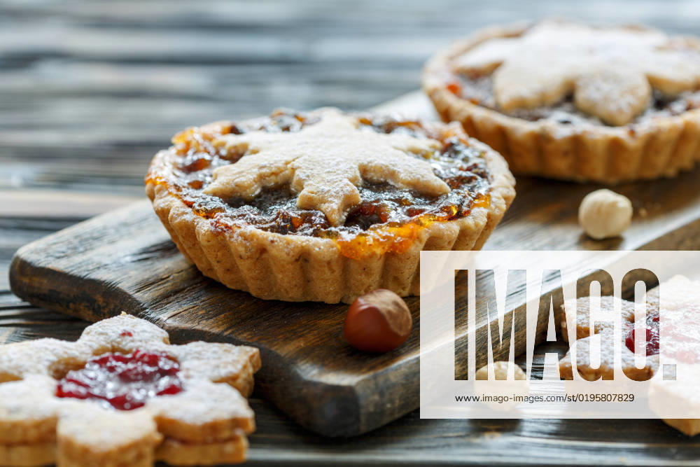 Cakes with dried fruits, orange jam and nuts. Christmas cakes with dried fruit and nuts on wooden table, selective focus.