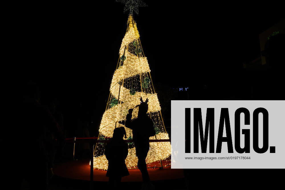 People taking pictures in front of a Christmas tree decorated on the eve of Christmas outside a mall in Lalitpur, Nepal on Saturday, December 24, 2022. Lalitpur Nepal - ZUMAg200 20221224_zap_g200_001