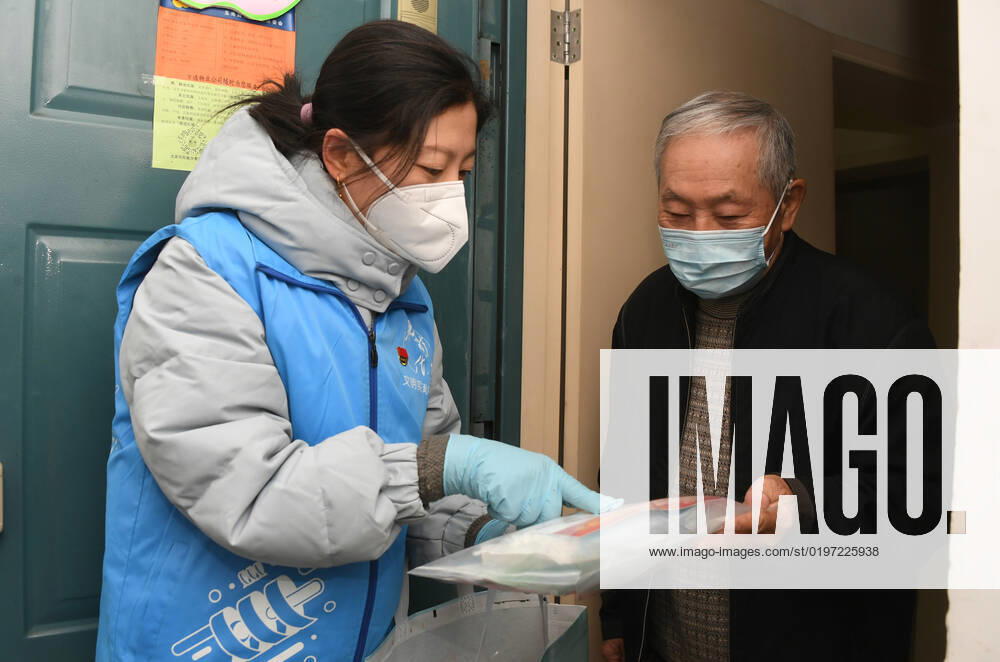 (221227) -- BEIJING, Dec. 27, 2022 -- A community worker (L) tells a resident the contents of a care package in a community in Yangfangdian Subdistrict of Haidian District in Beijing, capital of China, Dec. 27, 2022. In Yangfangdian Subdistrict, care packages including medicines and COVID-19 prevention materials have been offered for senior residents living alone and those with disabilities. Shared medical kits have also been provided for residents in case of emergency. ) CHINA-BEIJING-COVID-19 PREVENTION-CARE PACKAGES (CN) RenxChao