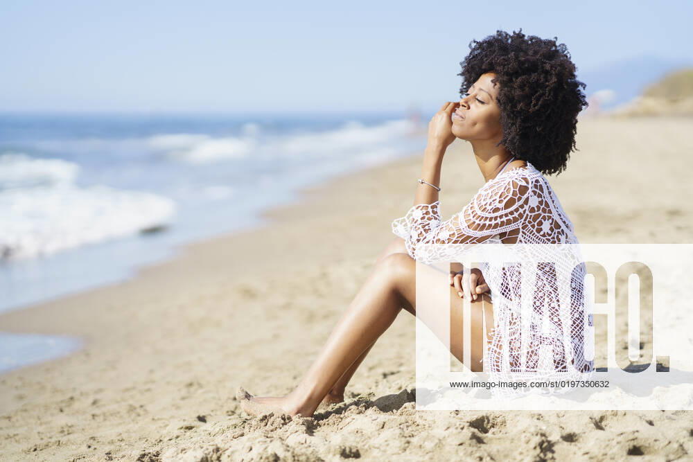 Young woman with eyes closed sitting on beach model released, Symbolfoto, JSMF02580