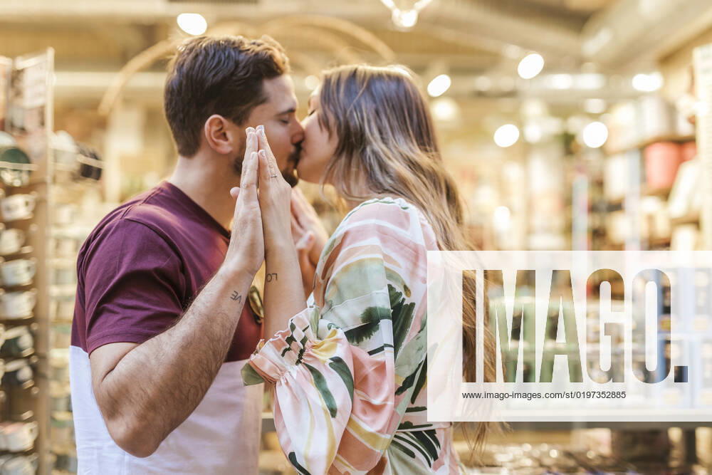 Affectionate man and woman kissing each other in store model released, Symbolfoto property released, LJF02372