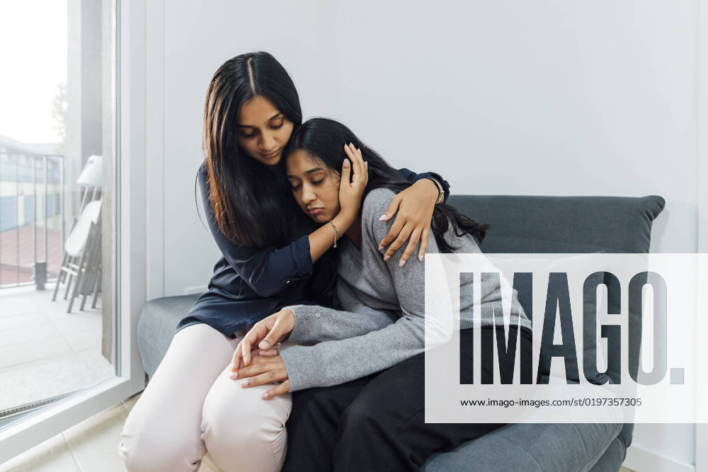 IMAGO Creative, Lifestyle, Leben in einer Wohngemeinschaft, WG Young woman consoling sister on sofa in living room model released, Symbolfoto property released, MEUF08657