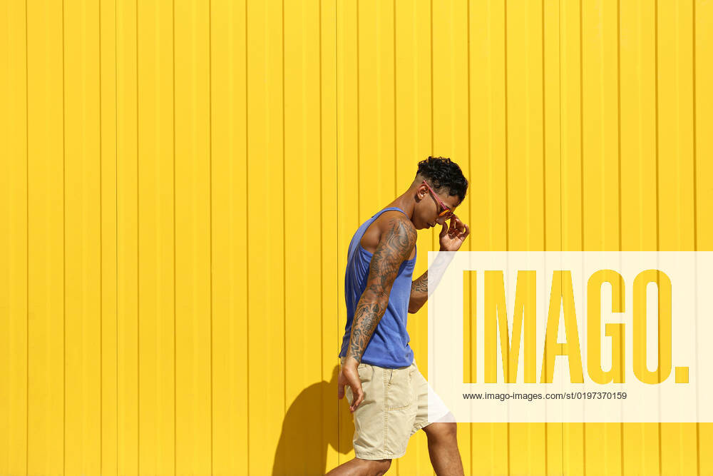 Young man dancing in front of yellow wall model released, Symbolfoto property released, SYEF00044