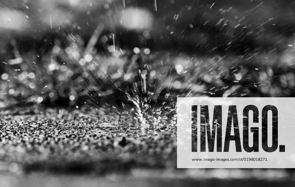 In heavy rain, large drops fall splashing on the ground in black an whtie, , , 31.08.2022,