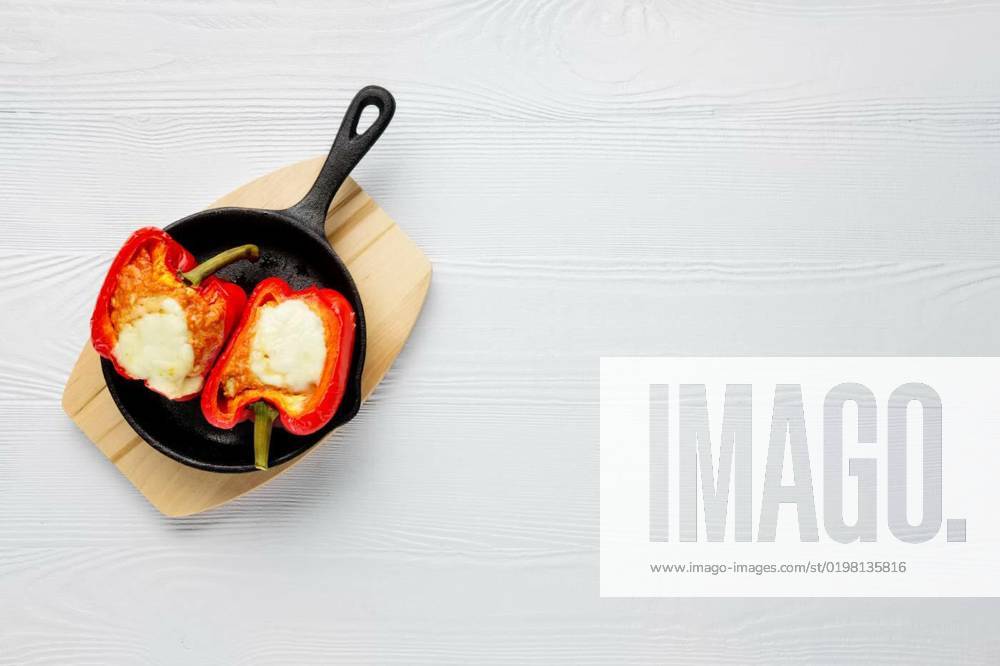 Bell pepper stuffed with meat with melted cheese mozzarella on top baked in oven in cast iron skillet. Top view. Natural wooden background., Bell pepper stuffed with meat with melted cheese mozzarella on top baked in oven in cast iron skillet. Top view. Natural wooden background., Bell pepper stuffed with meat with melted cheese mozzarella on top baked in oven in cast iron skillet. Top view. Natural wooden background., 12.10.2022,