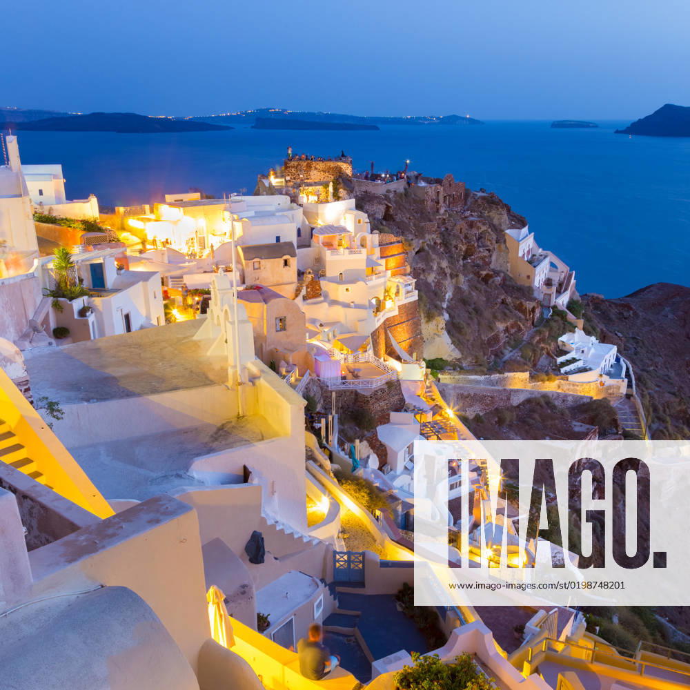 Oia village on Santorini in sunset, Greece. World famous traditional whitewashed chuches and houses of Oia village on Santorini island, Greece. Sunset.