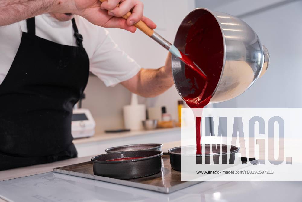 Hands one man, the to House a Red velvet cake bakes, by he the Biscuit in the form are, before he him in the Oven pushes Work to House