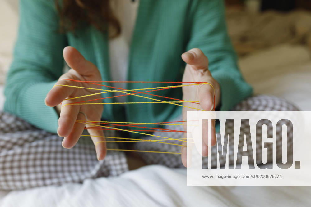 IMAGO Creative: Herbst, in Gesellschaft spielen Hands of woman playing cats cradle game at home model released, Symbolfoto property released, TYF00669