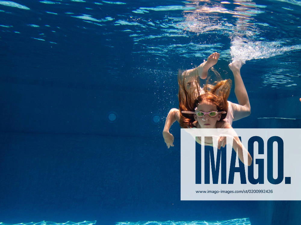 Girl child swims underwater in swimming pool in goggles in summer Gurnee, Illinois, United States CR_WVNP230125E-1091162-01 ,model released, Symbolfoto