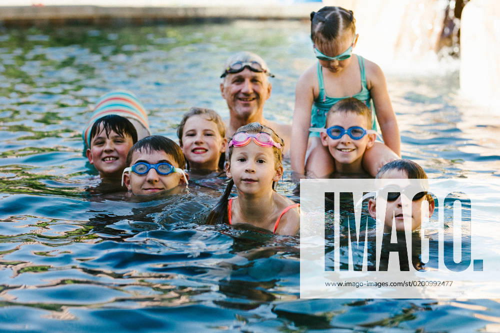Grandkids with grandpa in swimming pool with goggles in summer Gurnee, Illinois, United States CR_WVNP230125E-1091166-01 ,model released, Symbolfoto