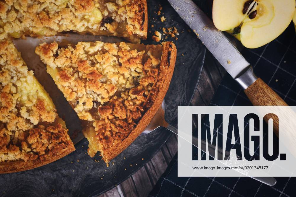 Disc Traditional European Apple pie with Crumble at cake server, surrounded from fresh Apples and Knives