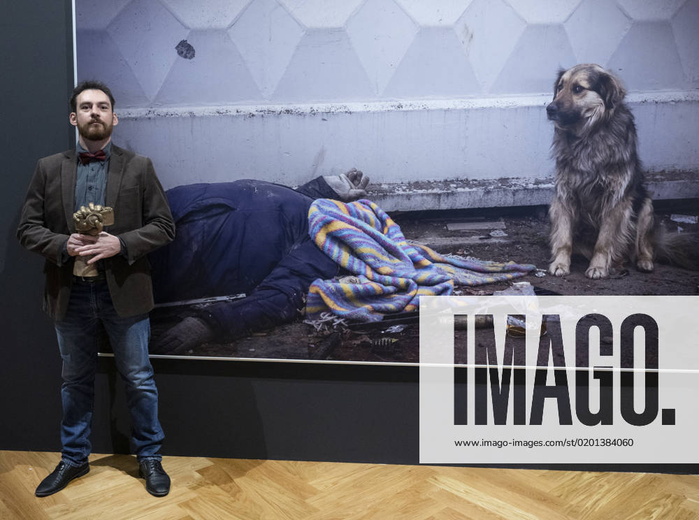 Czech photographer Vojtech Darvik Maca poses with the Czech Press Photo 2022 main prize in front of his winning photo from the massacre in Bucha, Ukraine, on January 31, 2023, in Prague, Czech Republic. (CTKxPhoto MichaelaxRihova) CTKPhotoP2023013108281 P2023013108281