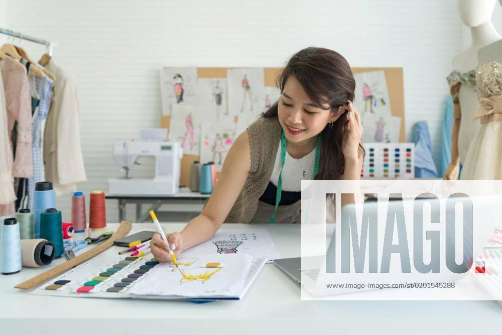 Young fashion designer use magic pen painting on pattern for cloth. Sewing Machine and various sewing related items are on the table. Asian woman working in home base cloth design business., Young fashion designer use magic pen painting on pattern for cloth. Sewing Machine and various sewing related items are on the table. Asian woman working in home base cloth design business., Young fashion designer use magic pen painting on pattern for cloth. Sewing Machine and various sewing related items are on the table. Asian woman working in home base cloth design business. model released, Symbolfoto property released , 06.01.2023,