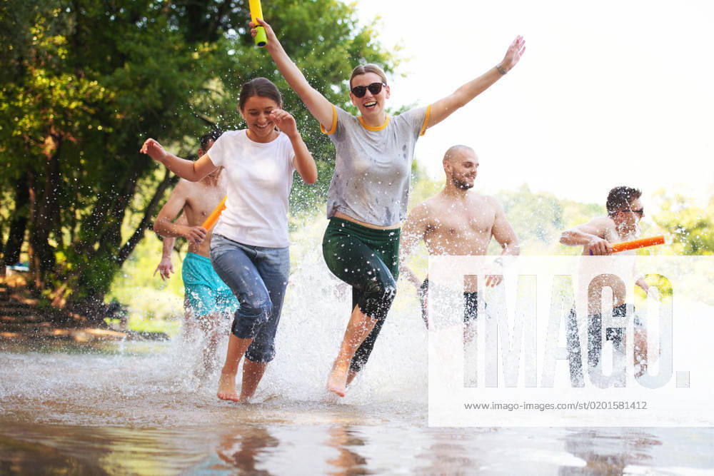 Summer joy friends having fun on river summer joy group of happy friends having fun while running and splashing on river