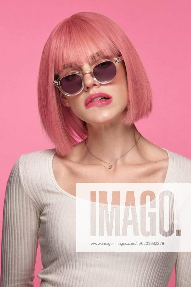 IMAGO Creative, Lifestyle, Barbiecore Beautiful funny cute woman in pink wig and classic makeup. Beauty face., Beautiful funny cute woman in pink wig and classic makeup. The portrait was shot in a studio on a pink background. Beauty face., Beautiful funny cute woman in pink wig and classic makeup. The portrait was shot in a studio on a pink background. Beauty face. model released, Symbolfoto , 24.01.2023,