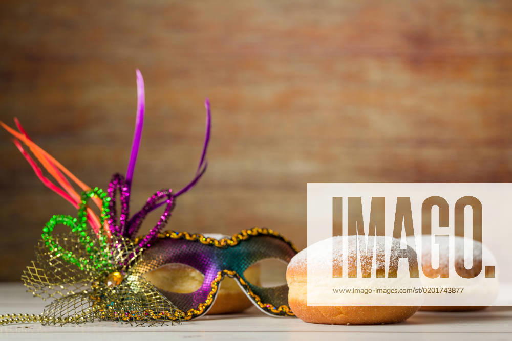 IMAGO Creative, Gesellschaft, Fasching Bavaria, Germany - 02 February 2023: Symbol image carnival and Rose Monday. Berliner, doughnut or pancake with a carnival mask
