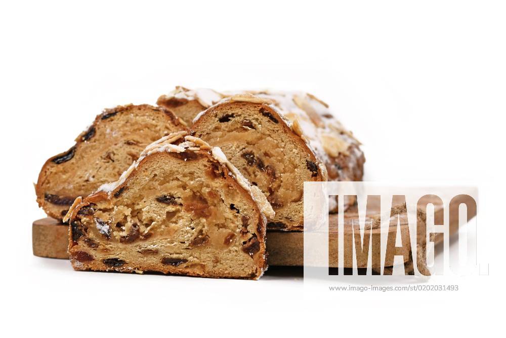 German Stollen, a Fruit bread with nuts, Spices and dried Or candied Fruit with Powdered sugar, the traditional to Christmas time at a Cutting board served becomes, before white Background