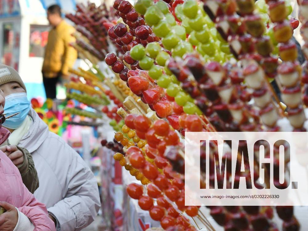 (230205) -- RENQIU, Feb. 5, 2023 -- Tourists taste Tanghulu, a traditional Chinese snack of candied fruit, in Houlihua Village of Renqiu, north China s Hebei Province, Feb. 5, 2023. People celebrate the Lantern Festival, the 15th day of the first month of the Chinese lunar calendar, with various traditional customs across the country. ) CHINA-LANTERN FESTIVAL-TRADITIONAL CUSTOM (CN) MuxYu