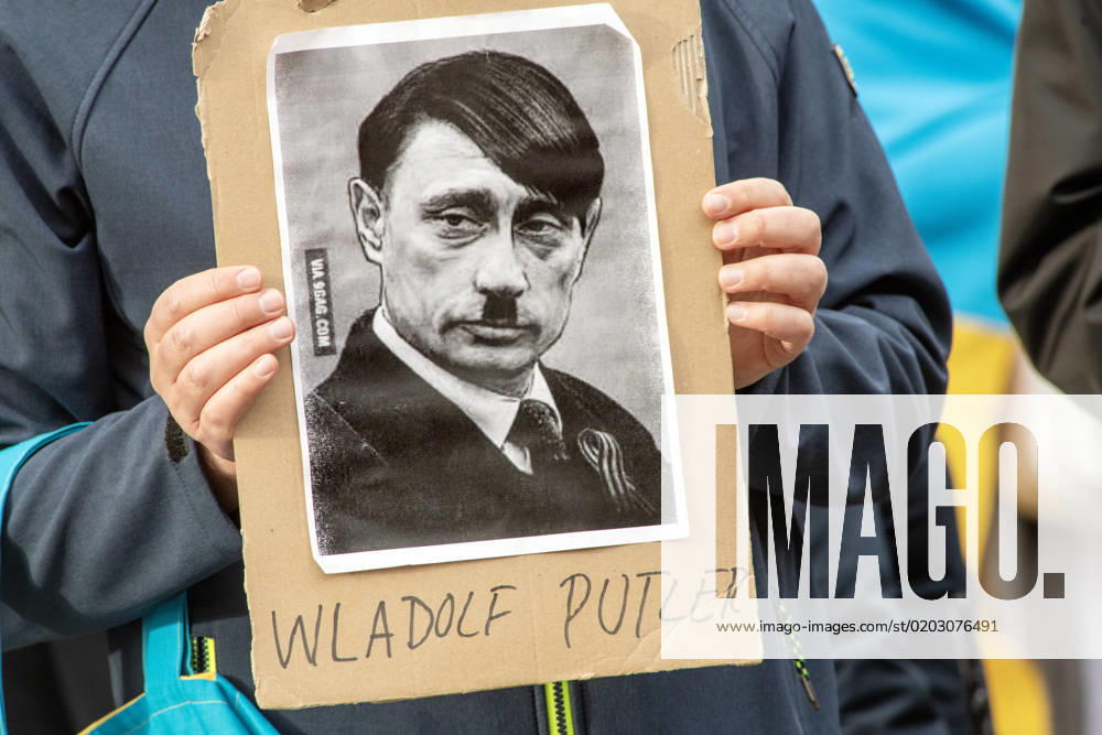 Wladolf Putler, poster shows Putin as Hitler, Pro Ukraine Demo at Odeonsplatz, Munich, 18 02 2023 Germany, Munich, 18 February 2023, Wladolf Putler, demonstrator holds sign with Putin as Hitler, Pro Ukraine Demo at Odeonsplatz, organized by Alliance Ukrainians in Munich , rally, demonstration on the occa
