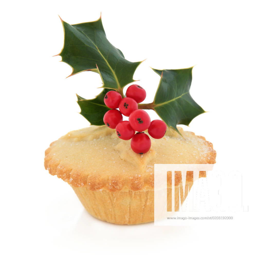 Christmas mince pie with holly and red berry leaf sprig over white background.