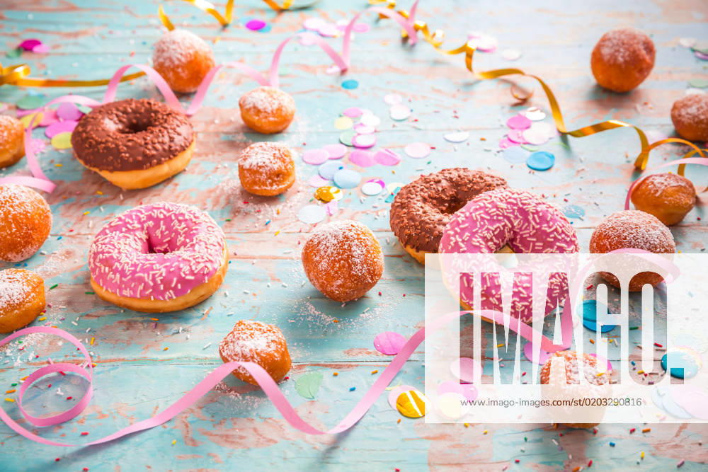 Traditional Berliner for carnival and party. German Krapfen or donuts with streamers and confetti. Colorful carnival or birthday image Traditional Berliner for carnival and party. German Krapfen or donuts with streamers and confetti. Colorful carnival or birthday image