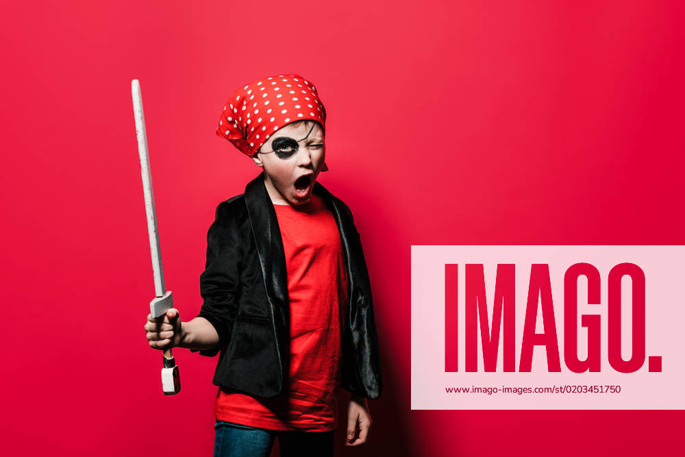 IMAGO Creative, Gesellschaft, Fasching Cute boy in pirate outfit with sword screaming and looking at camera against bright red background, Model released HodeiUnzueta_ID12912_392224_006
