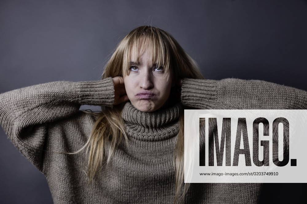 Boy Woman with long, blonde Hair and eimem Wollpullover interlaced Arms behind the Head and forgiven the Face, Portrait, Studio recording