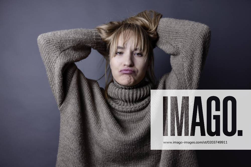 Boy Woman with long, blonde Hair and eimem Wollpullover interlaced Arms behind the Head and forgiven the Face, Portrait, Studio recording