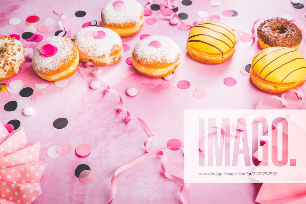 Traditional Berliner for carnival and party. German Krapfen or donuts with streamers and confetti. Colorful carnival or birthday image Traditional Berliner for carnival and party. German Krapfen or donuts with streamers and confetti. Colorful carnival or birthday image