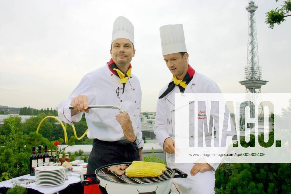 DSF Reporter Thomas Helmer (li.) und Fredi Bobic (beide Deutschland) rösten und grillen im Schatten des Berliner Funkturms Maiskolben und saftige Steaks auf einem Fußballgrill Fußball Herren WM 2006 Gruppe Kochsendung Berlin Fußball Herren WM 2006 Gruppe Kochsendung Berlin