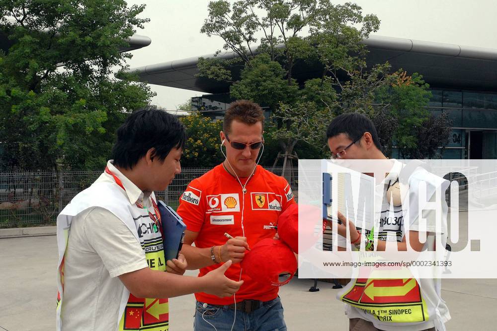 Michael Schumacher (Deutschland Ferrari, Mitte) verteilt Autogramme an Streckenhelfer Motorsport Grand Prix Herren Großer Preis von China 2006, Formel 1 Weltmeisterschaft, F1, F, GP, WM, Freies Training Gruppe Shanghai Motorsport Grand Prix Herren Großer Preis von China 2006, Formel 1 Weltmeisterschaft, F1, F, GP, WM, Freies Training Gruppe Shanghai