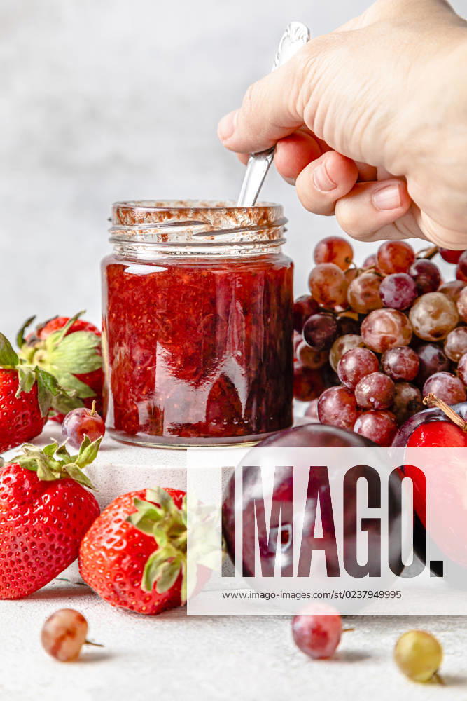 IMAGO Creative, Jahreszeit Sommer, Food, Marmelade kochen Hand of woman holding spoon with homemade strawberry jam on table model released, Symbolfoto, FLMF00932
