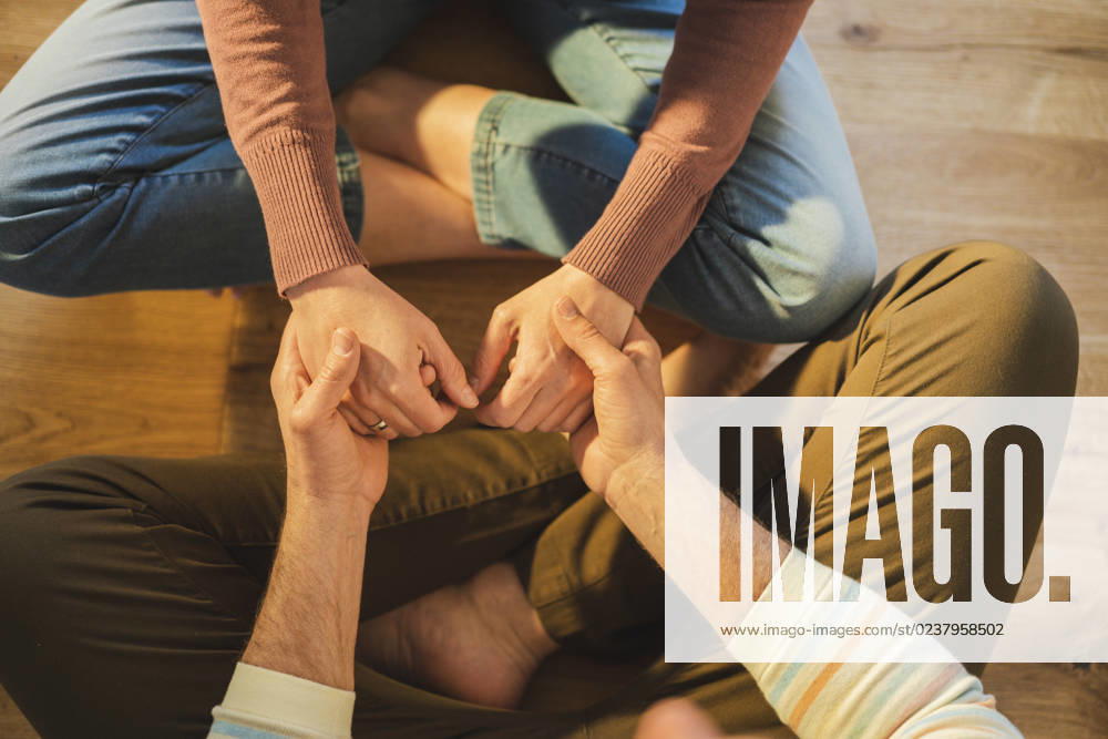 Husband and wife holding hands sitting cross-legged at home model released, Symbolfoto property released, JOSEF16676
