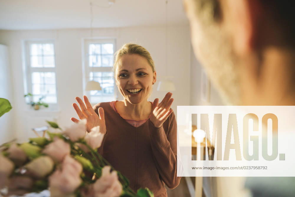 Surprised woman looking at flowers in living room model released, Symbolfoto property released, JOSEF16758