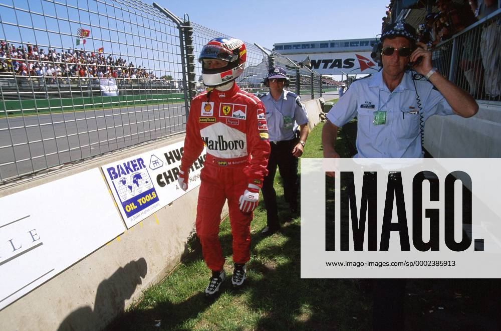 Michael Schumacher (Deutschland Ferrari) lässt sich nach seinem Ausfall in Australien 1998 von Race Marshalls begleiten Motorsport Grand Prix Herren Großer Preis von Australien 1998, Formel 1 Weltmeisterschaft, F1, F, GP, WM Gruppe Albert Park Melbourne Enttäuschung Motorsport Grand Prix Herren Großer Preis von Australien 1998, Formel 1 Weltmeisterschaft, F1, F, GP, WM Gruppe Albert Park Melbourne Enttäuschung