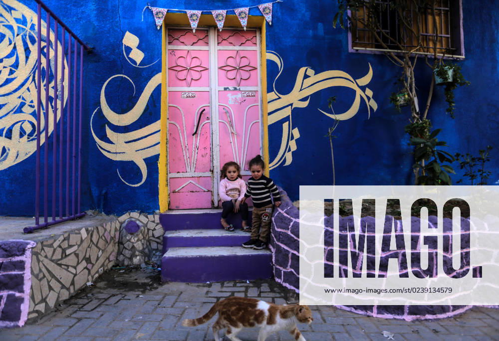 Children sit at the doorstep of a house, painted in vivid colours as part of an initiative by a Palestinian artist, in the Zeitun district of Gaza City, on March 12, 2023. Gaza City Palestine - ZUMAq100 20230312_zaa_q100_026