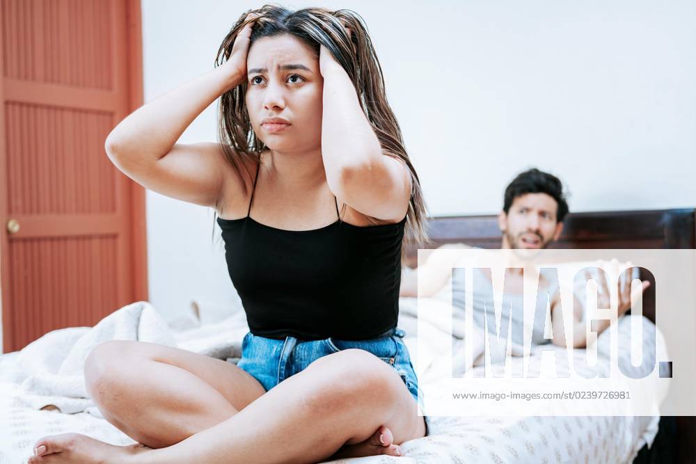 Young one pair disputes itself at the Bed sitting Concept the pair Problems at Bed upset Woman with Man sits at the Bed, Woman disputes with their Man at Bed