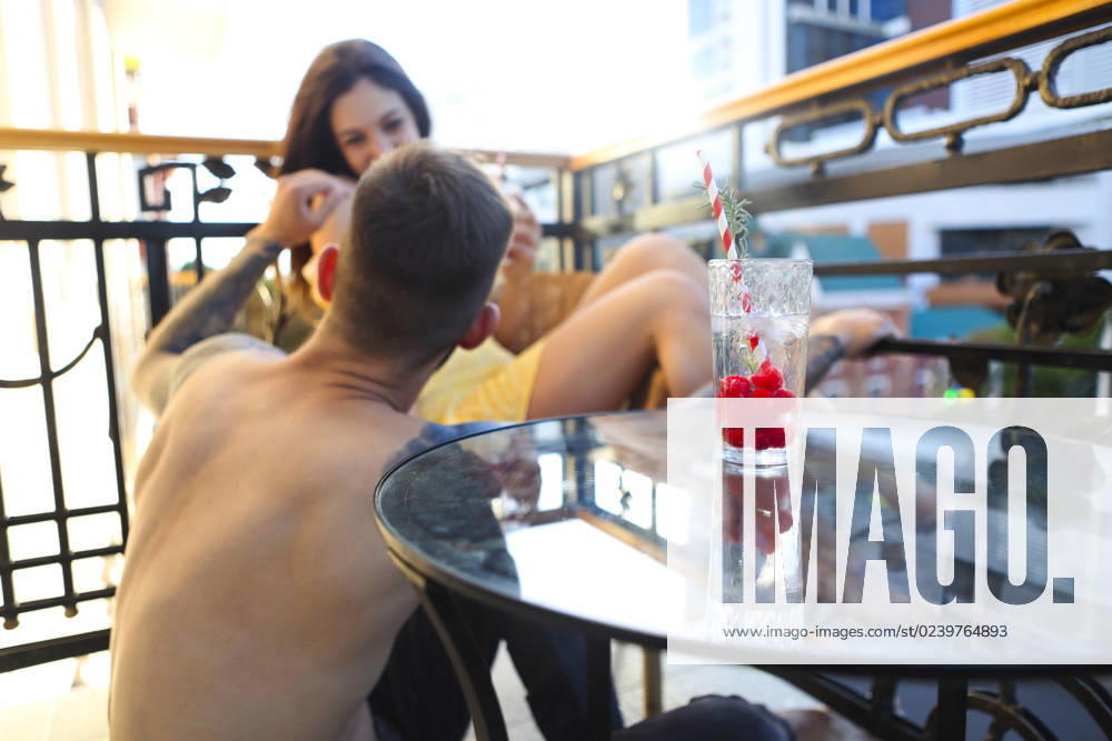 Couple in love drinking summer refreshing lemonade with rasberry on a balcony Happy couple in love drinking summer refreshing lemonade with rasberry on a balcony ,model released, Symbolfoto ,property released