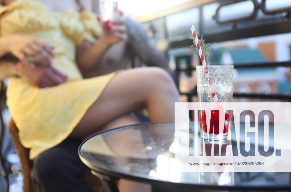 Couple in love drinking summer refreshing lemonade with rasberry on a balcony Happy couple in love drinking summer refreshing lemonade with rasberry on a balcony ,model released, Symbolfoto ,property released