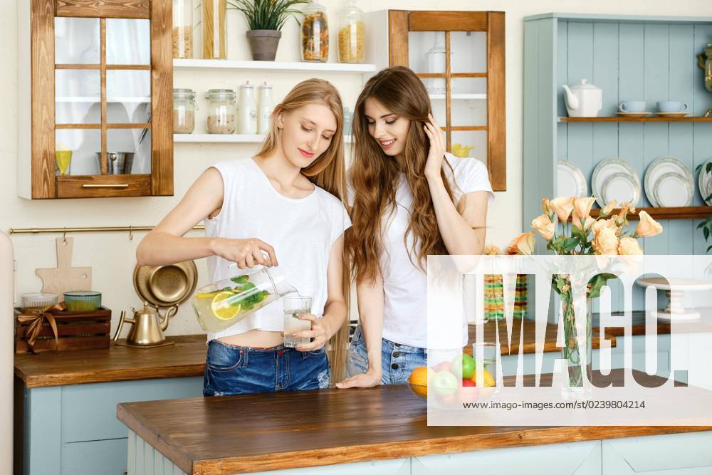 Two pretty Girls drink Lemonade and maintained itself in the Kitchen