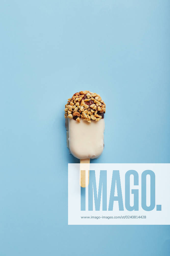 Mousse dessert with fruit flavors in the form of popsicle ice cream on blue background. Mousse dessert with fruit flavors in the form of popsicle ice cream covered with white chocolate on blue background.