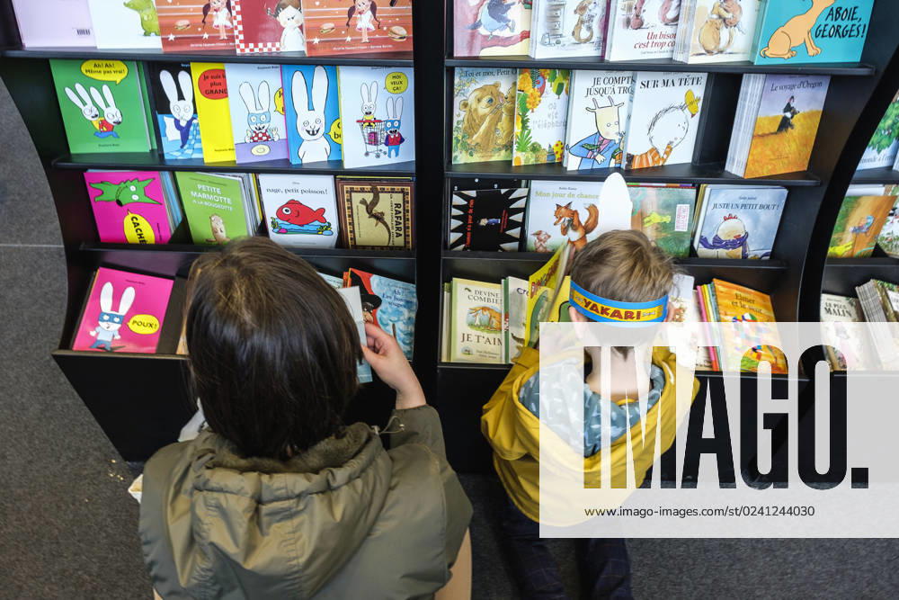 Foire du Livre de Bruxelles les gens se pressent autour des presentoirs 2023 Choisir un livre maman et enfant Brussels Books fair 2023 - Picking a book child and mother Reporters QUINET JEANxMARCxQUINET