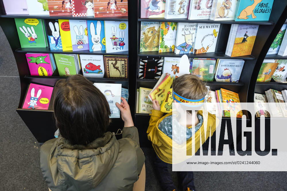 Foire du Livre de Bruxelles les gens se pressent autour des presentoirs 2023 Choisir un livre maman et enfant Brussels Books fair 2023 - Picking a book child and mother Reporters QUINET JEANxMARCxQUINET